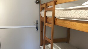 Una cama litera con una escalera, una puerta con manija y una pared blanca.