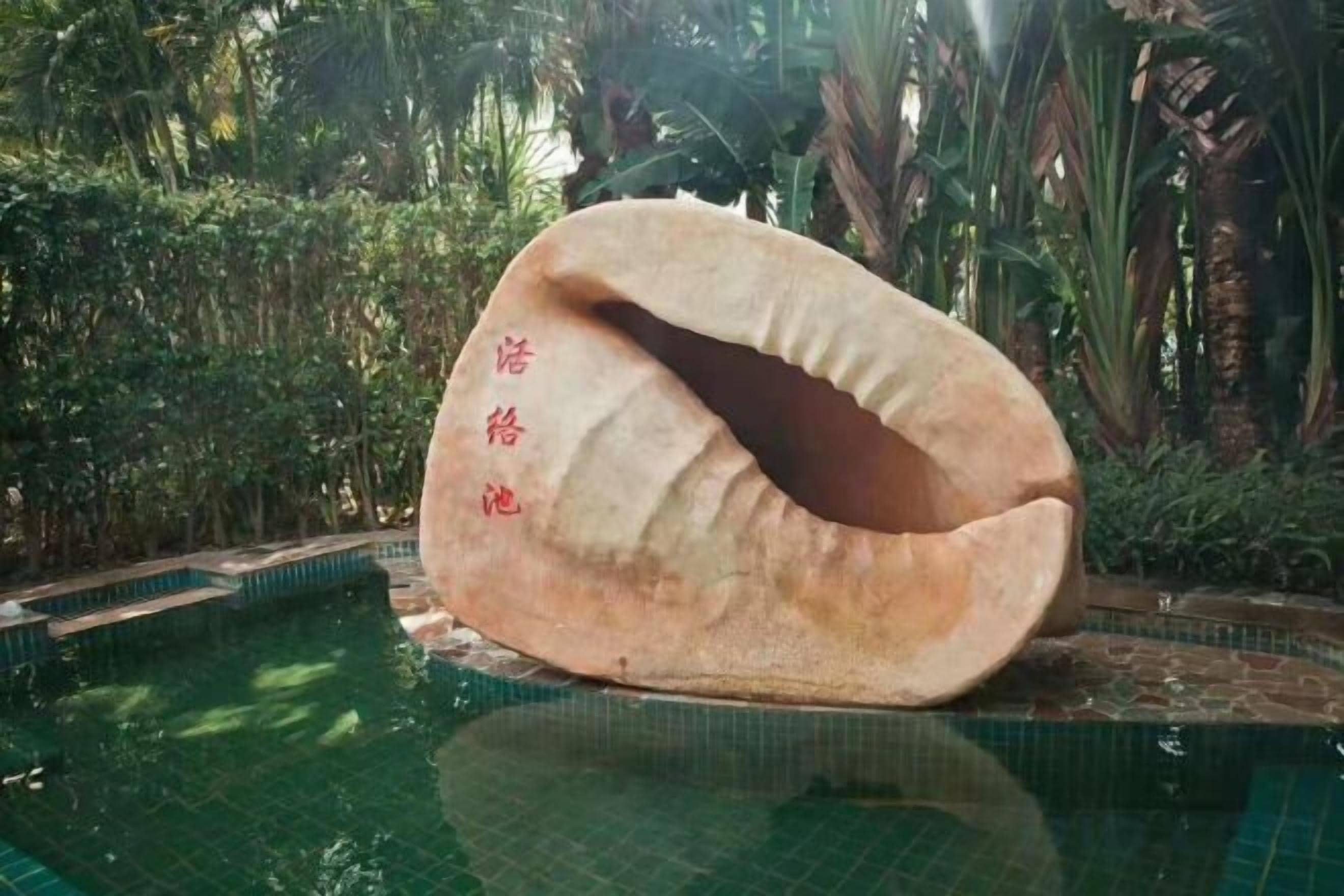 Una gran estructura con forma de concha en una piscina con caracteres chinos.
