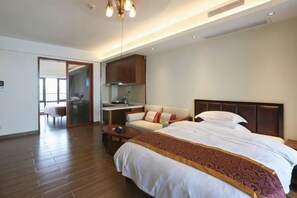 A hotel room with a bed, a sofa, a desk, and a kitchenette. - Huidong Shuangyue Bay Rainbow Bay Sea View Hotel (Huidong)