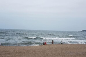 A beach with waves, a sandy shore, and a distant landmass. - Huidong Shuangyue Bay Rainbow Bay Sea View Hotel (Huidong)