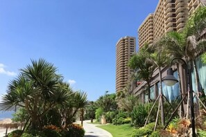 A hotel with tall buildings, palm trees, and a pathway.