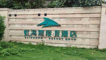 Een bord voor Rainbow Resort met een logo en naam in Chinese karakters.