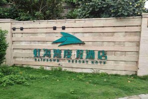 A sign for Rainbow Resort with a logo and name in Chinese characters. - Huidong Shuangyue Bay Rainbow Bay Sea View Hotel (Huidong)