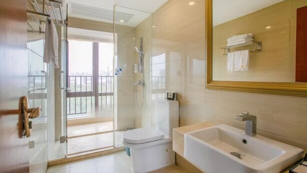 A modern bathroom with a glass-enclosed shower, a white toilet, and a freestanding bathtub. - Huidong Shuangyue Bay Rainbow Bay Sea View Hotel (Huidong)