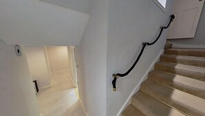Eine Treppe mit Handlauf und einer Tür am oberen Ende.