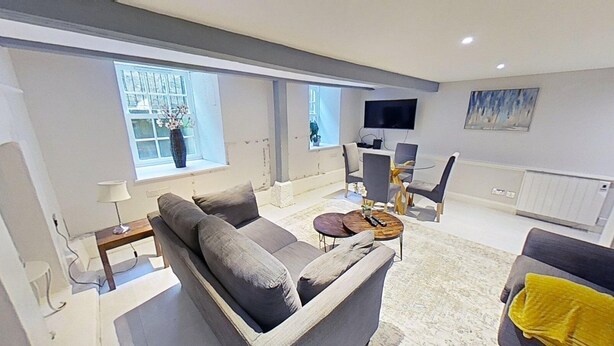 Ein modernes Wohnzimmer mit Sofa, Couchtisch und Fernseher.
