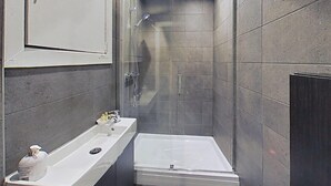 Ein modernes Badezimmer mit Dusche, Waschbecken und Badewanne.