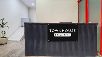 Una mesa de recepción con un cartel que dice 'TOWNHOUSE Company-Serviced'.