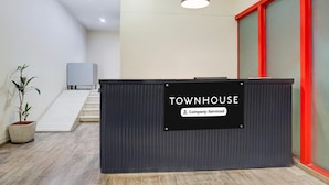 Zona de recepción con un cartel que indica 'TOWNHOUSE Company-Serviced'.