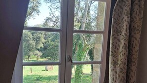 Quarto com janela saliente dando para um jardim.