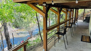 Une terrasse en bois offrant une vue sur une rivière et des arbres.