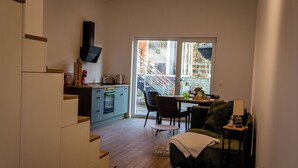 A compact kitchen with a dining area, a sofa, and a staircase leading to an outdoor area. - Vacation apartment in Hövelhof - 55sqm in a quiet location (Hövelhof)