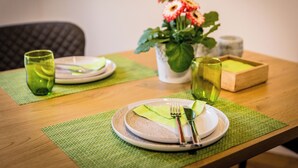 A dining table set with plates, cutlery, and glasses on a green placemat. - Vacation apartment in Hövelhof - 55sqm in a quiet location (Hövelhof)