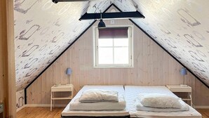 A room with two beds, a window, and a sloped ceiling. - 4 Star Holiday Home in Burgsvik (Burgsvik)