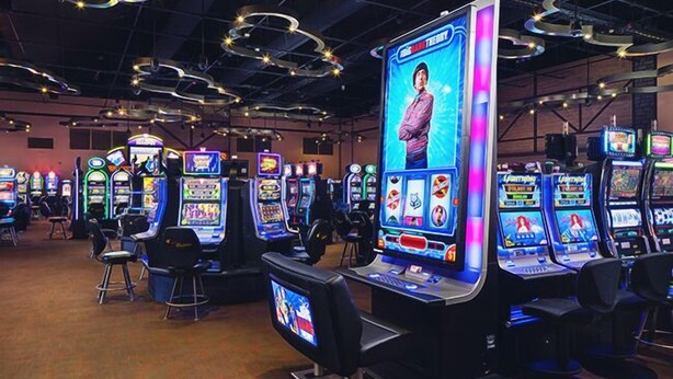 Una sala de juegos recreativos con varias máquinas de videojuegos y sillas cómodas.