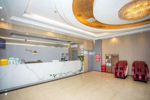 A reception area with a marble counter, a chandelier, and two massage chairs. - GreenTree Inn (Shanghai Fengxian Xidu) (Shanghai)