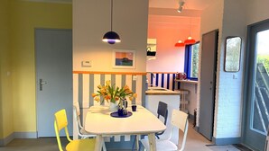 A dining area with a table, chairs, and a vase of flowers. - Holiday Home in Noordwijkerhout Near Lake (Noordwijkerhout)
