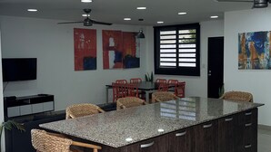 A modern kitchen with a central island, recessed lighting, and a ceiling fan. - Family House 6 Private Rooms, Antiguo Cuscatlán (Antiguo Cuscatlan, Zona Uca)