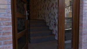 Una escalera con pared estampada, muros de ladrillo y barandilla de metal.