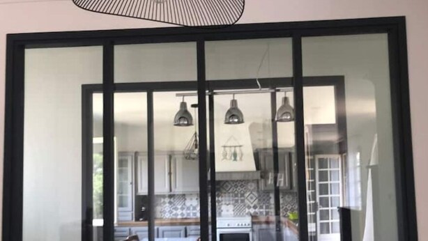 Cozinha moderna com uma janela grande, luminárias pendentes e painel de azulejos.