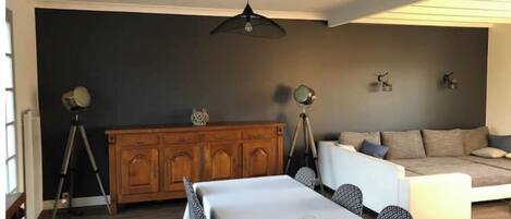 Una sala moderna con comedor, un sofá y un mueble de madera.
