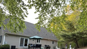 A house with a covered patio, outdoor furniture, and a grill.