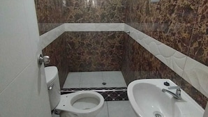 Une petite salle de bain avec des toilettes, un lavabo et une douche.
