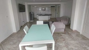 Un espace de vie compact comprenant un coin repas, une kitchenette et un canapé.