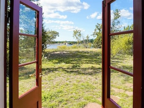 An open door with a view of a grassy area and a body of water. - 6 Person Holiday Home in Oskarshamn (Oskarshamn)