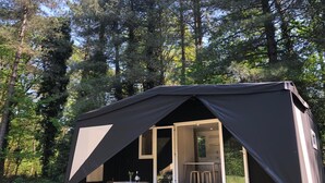 A black tent with a table and chairs outside, surrounded by trees. - Lodge Near Antwerp With Nature Trails (Lille)