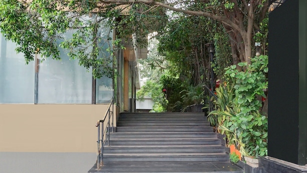 Un escalier extérieur menant à un bâtiment, entouré de verdure et de plantes.
