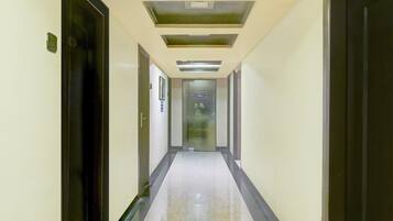 Un corridoio con porte su entrambi i lati, un soffitto con illuminazione a incasso e un cartello che indica un ufficio.
