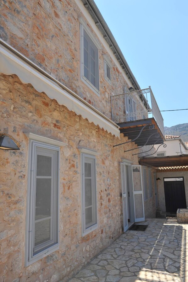 A stone building with multiple windows and a balcony.
