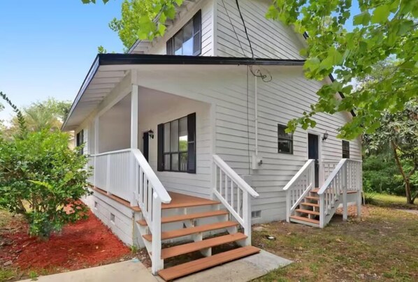 A two-story house with a covered porch and a small front yard. - Charming 2-bedroom house with AC, WiFi in wonderful St. Augustine (St. Augustine)