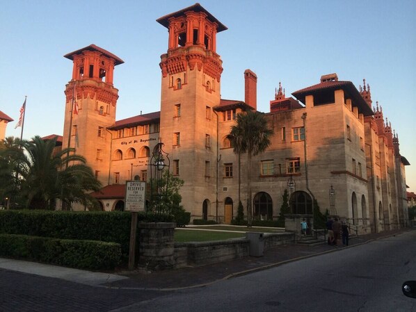 A historic building with a central tower, arched windows, and a courtyard.