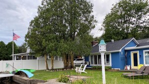 Ein Wohnhaus mit Teich, Sitzgelegenheiten im Freien und einem blauen Haus.