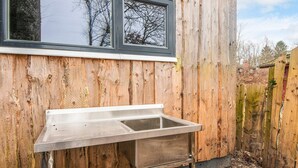Une structure en bois avec un évier et une fenêtre en métal.