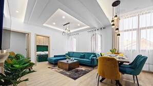A modern living room with a sectional sofa, a coffee table, and a dining area with chairs and a table. - 2 Bedroom Charming Apartment in Pula (Pula)