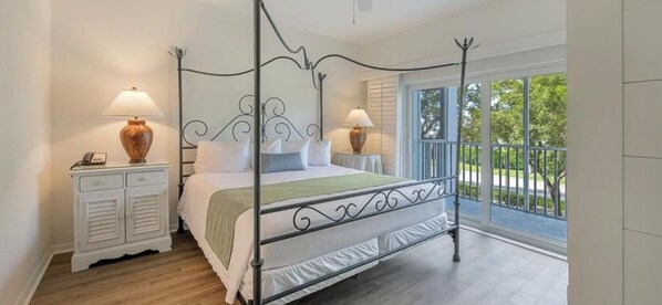 A four-poster bed with a metal frame, white bedding, and two bedside lamps. - Elite Premier Summer Special: Charming 2BR Condo in Gorgeous Marco Island (Marco Island)