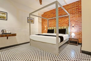 A room with a four-poster bed, a brick wall, and a tiled floor.