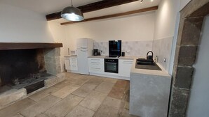 A modern kitchen with white cabinetry, a built-in oven, a microwave, and a black sink. - Quiet 3-star gite for 6 to 8 people with view, 5min from St Guilhem le désert (Arboras)