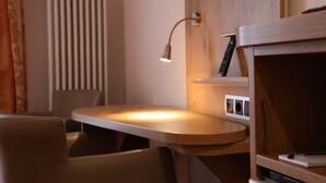 A modern room with a wooden desk, a chair, a lamp, and a radiator. - Hotel an der Therme (Bad Durkheim)