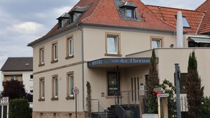 A hotel with a sign reading "HOTEL an der Thiem" and a staircase leading to the entrance. - Hotel an der Therme (Bad Durkheim)
