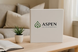 A white box with the Aspen Vacation Rentals logo on a wooden table.