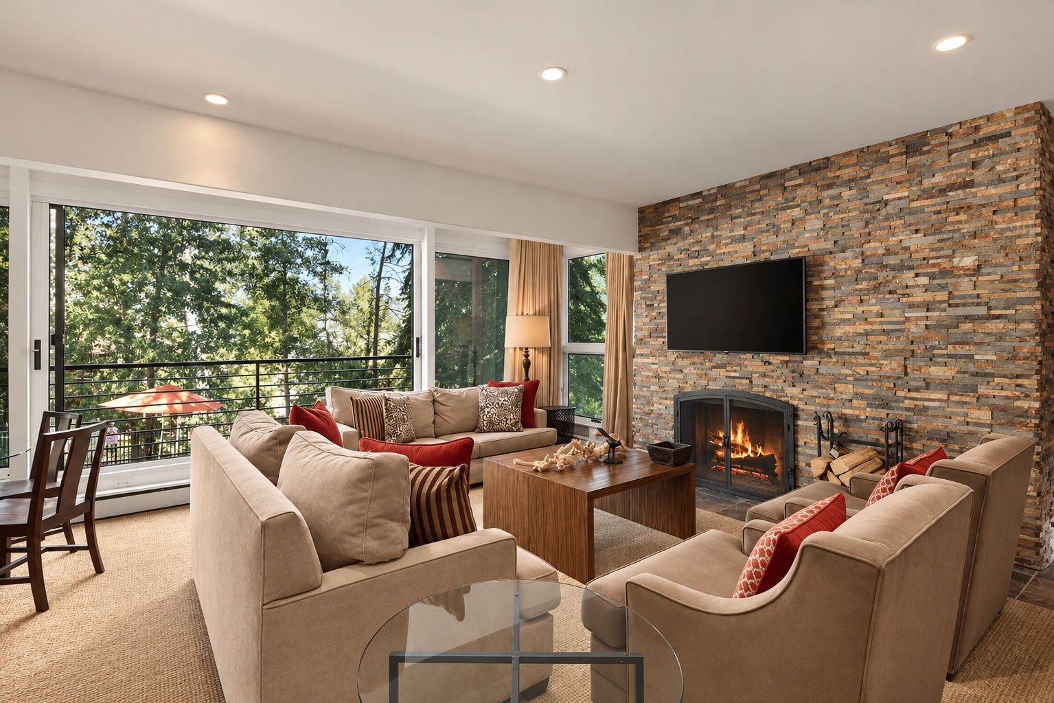 A modern living room with a stone fireplace, comfortable seating, and a large window overlooking greenery.
