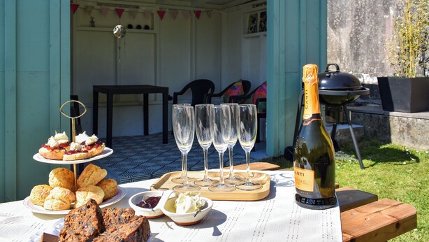 A table set for a meal with various pastries, a bottle of Canti wine, and empty wine glasses. - Escape to Barnhayes, a charming retreat in the picturesque village of Hartland. (Hartland)