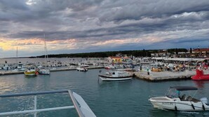 A marina with boats docked, a pier with people, and buildings in the background. - Apartment in Valbandon Near Beach & Pool (Fazana)