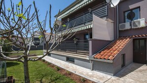 A modern building with a sloped roof, satellite dish, and air conditioning units. - Lovely Relaxing Studio With Terrace (Fazana)