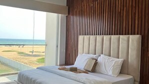 Una camera da letto moderna con un letto grande, una parete in legno e vista sulla spiaggia.