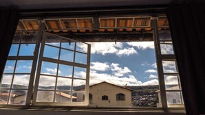 A window with multiple panes, offering a view of a building and a cloudy sky. - Comfort Suite 302 (Diamantina)